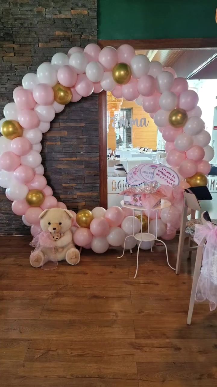 Arco de globos rosas y dorados con osito de peluche para una primera comunión en Antequera