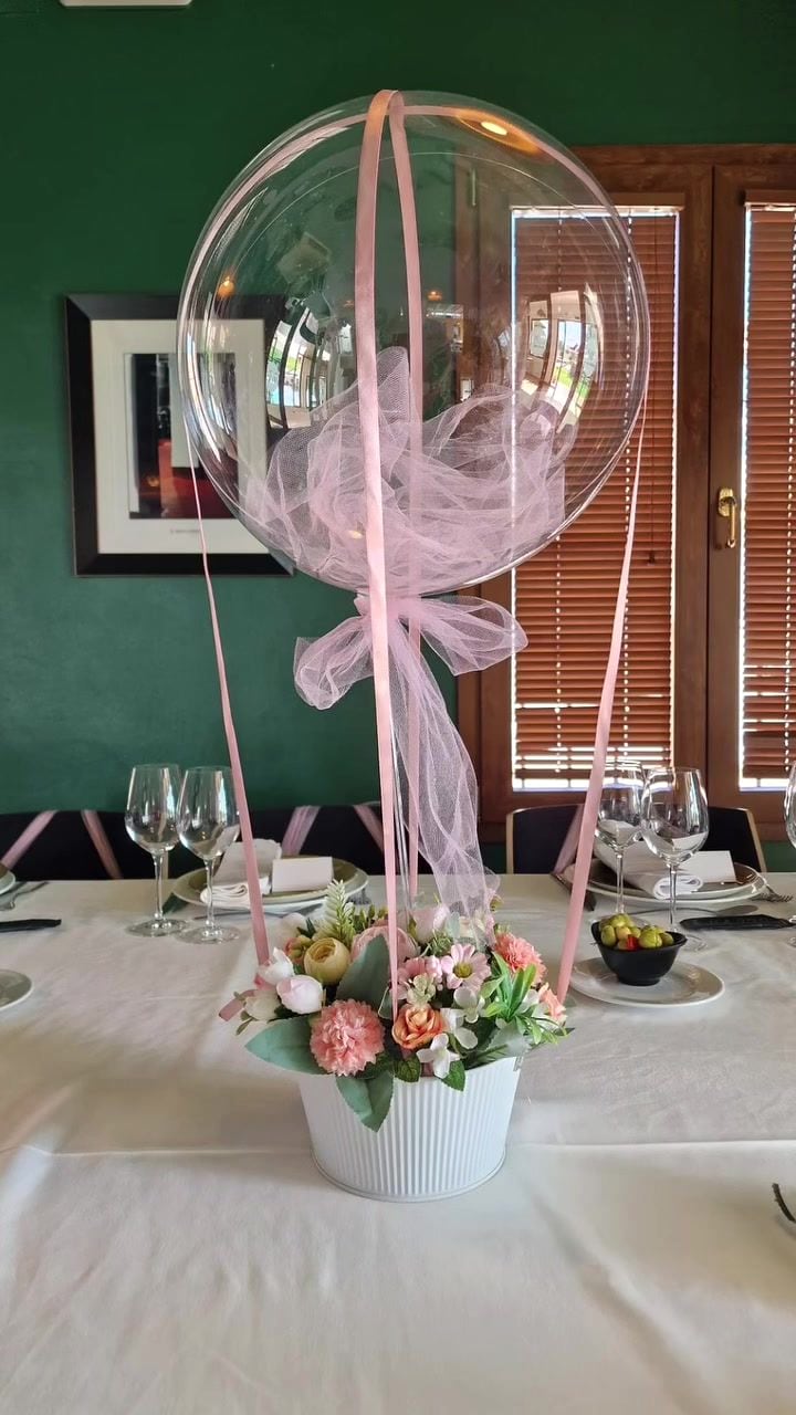 Centro de mesa con globo transparente, plumas y flores