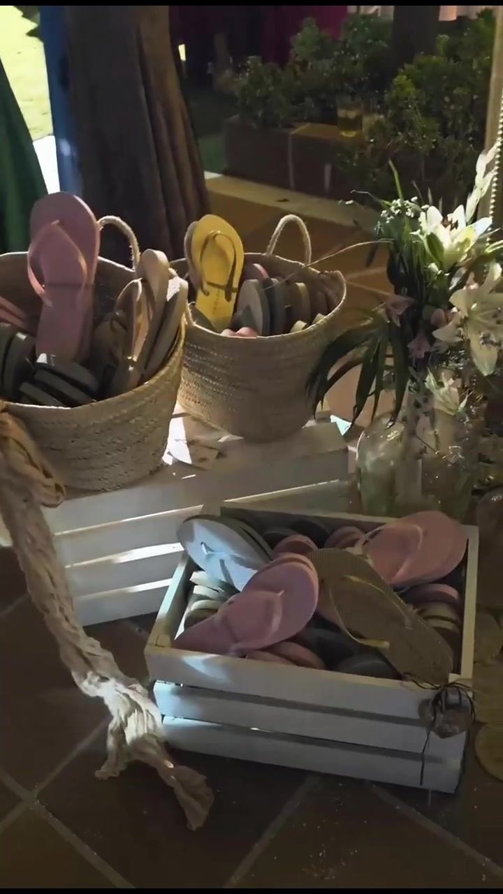 Cestas de mimbre con alpargatas y abanicos para los invitados de la boda