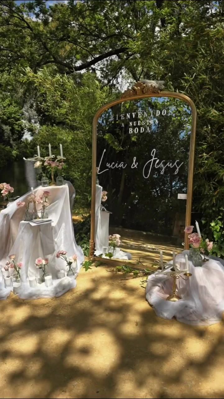 Espejo de bienvenida con candelabros y tul en el jardín de la Hacienda Romeral