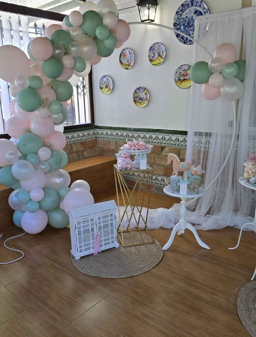 Arco de globos verde menta y rosa con jaula decorativa blanca