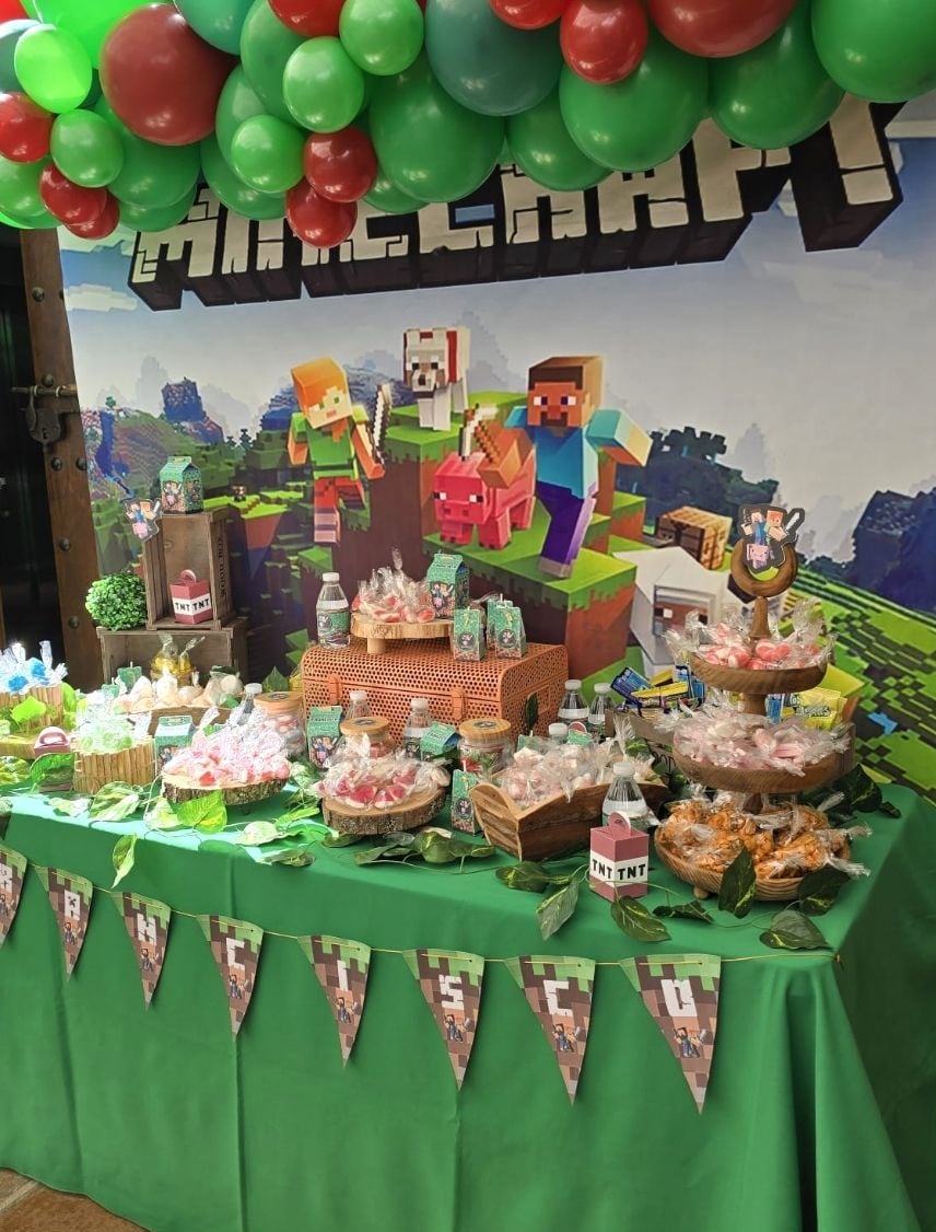 Mesa dulce de comunión con temática de videojuego y globos verdes y rojos